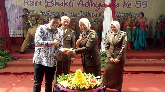 Kajari Kota Kediri Dra. Martini, SH saat memberikan potongan tumpeng kepada Walikota Kediri Abdullah Abubakar, SE. foto:aji